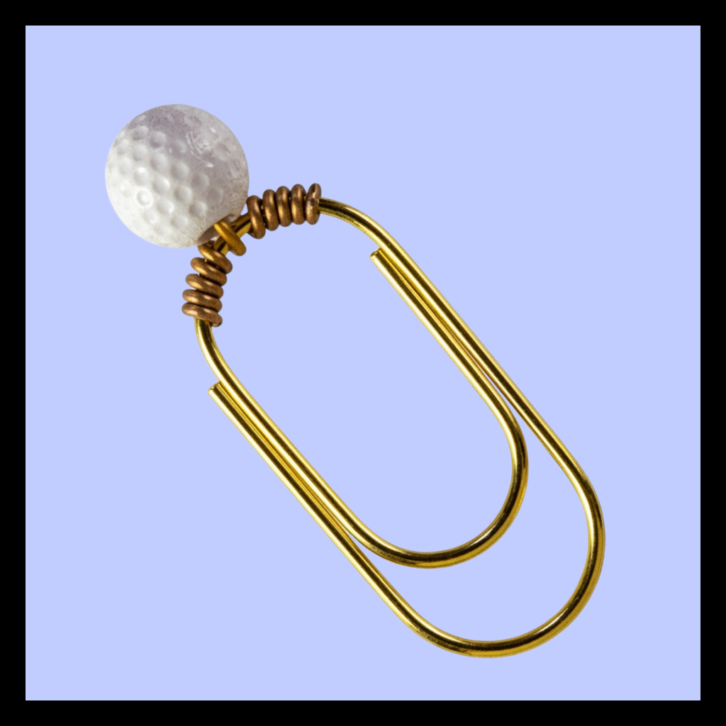 A novelty paperclip earring featuring a gold-plated paperclip body with a small coiled gold accent and a white textured golf ball bead, shown against a light blue background.