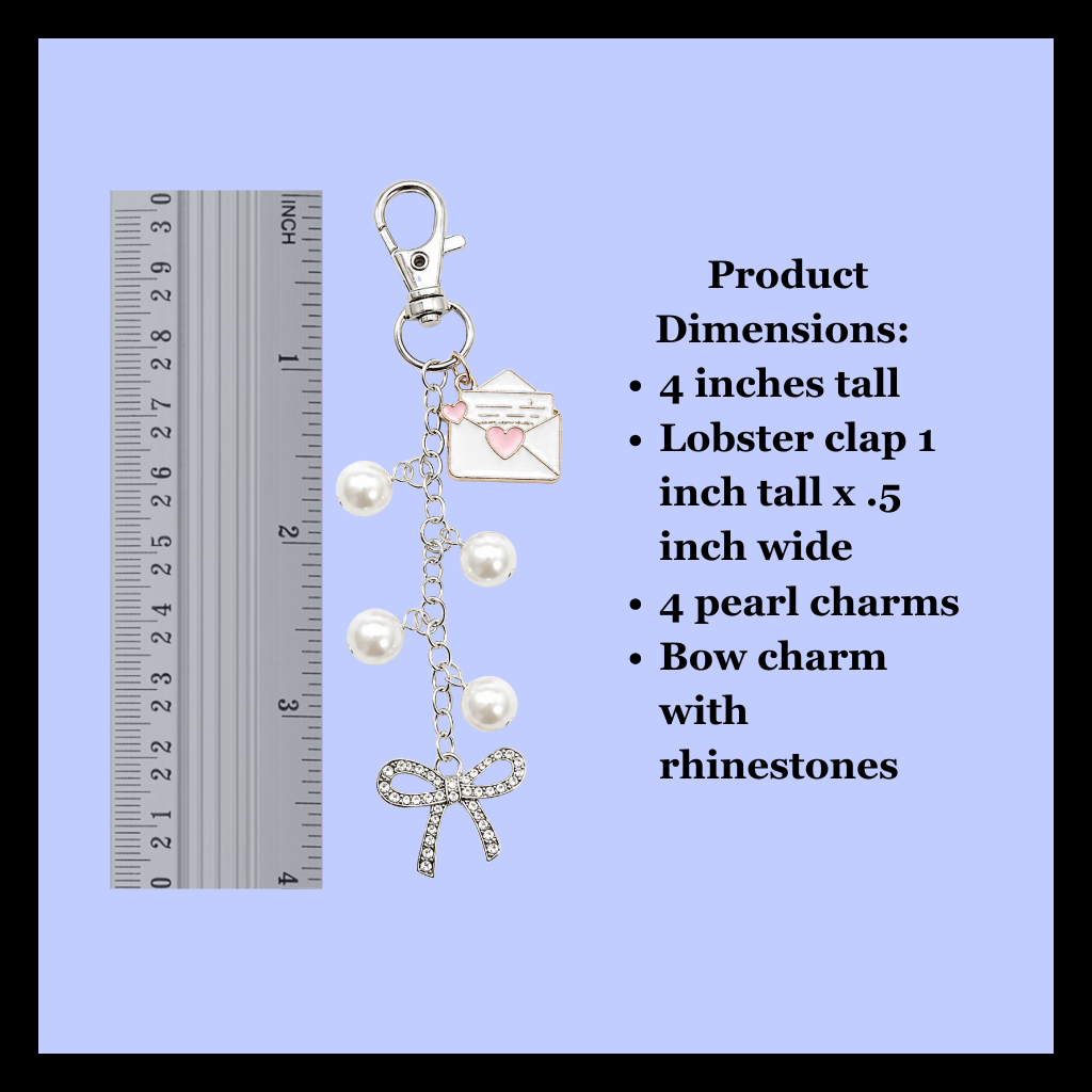 Silver-tone lobster clasp keychain charm with pearl charms, rhinestone bow, and envelope charm, shown next to a ruler and product dimensions text on a light blue background.