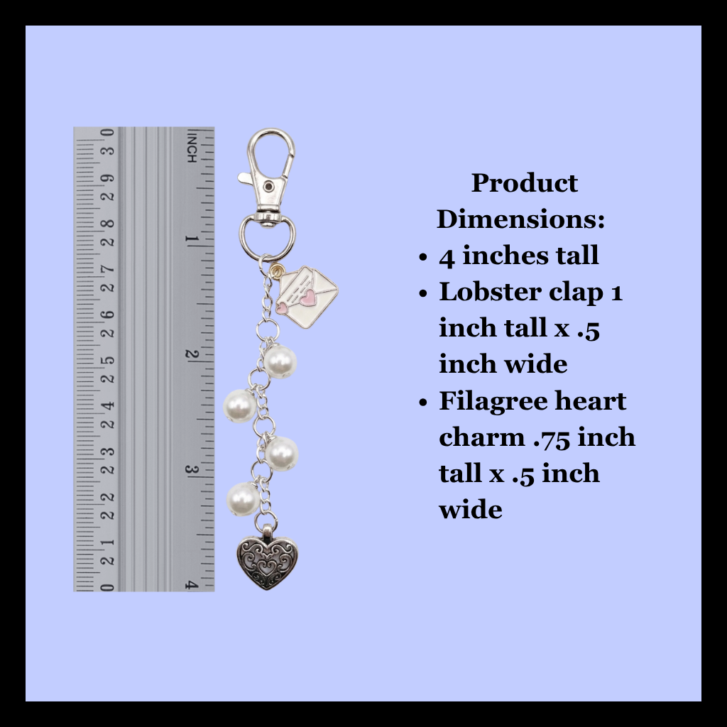 Silver lobster clasp keychain charm with white pearl beads, a silver filigree heart charm, and a small envelope charm, shown next to a ruler for scale and product dimensions text on a light blue background.