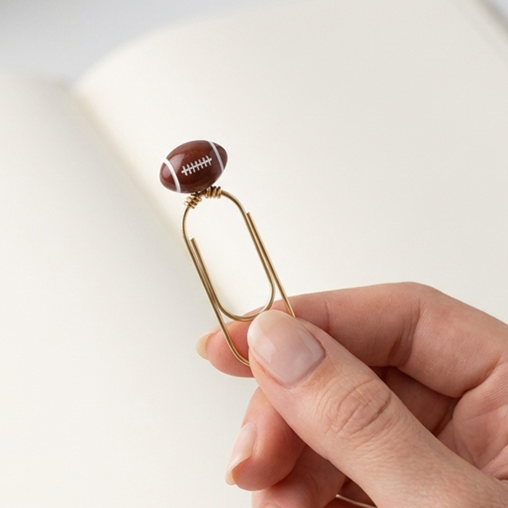 Metal Clip Bookmark With Miniature Football Charm Brown Leather Look Ball White Stitching Detail Gold Finish Hardware Sports Theme Reading Gift Book Lover Present Compact Two Inch Design Lightweight Page Marker Athletic Style Accessory